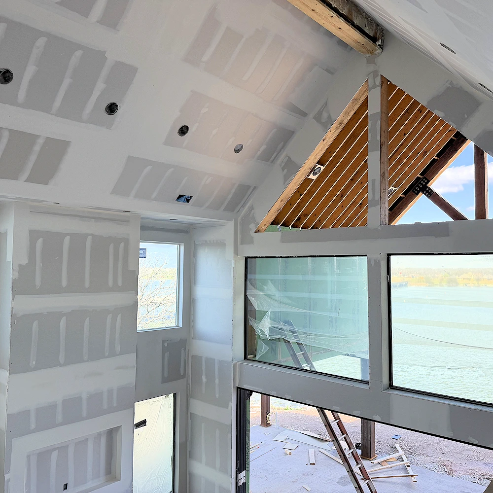 Hanging drywall on a second story ceiling.