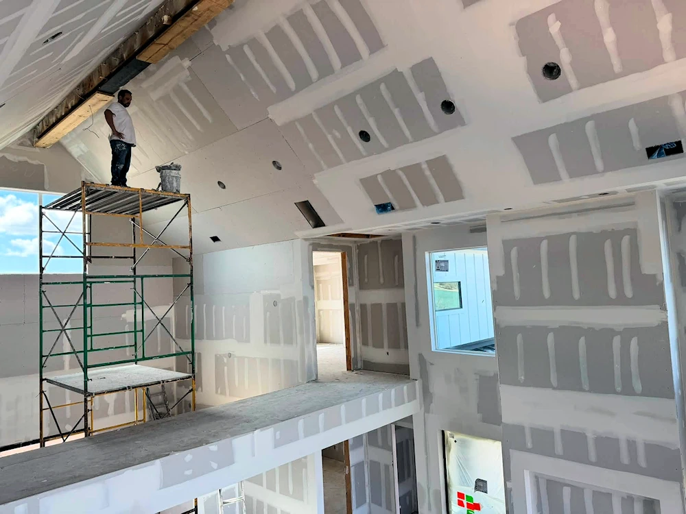 Hanging drywall on a second story ceiling.